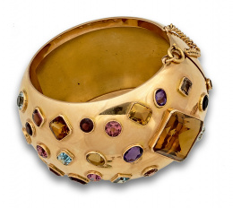 572.  Brazalete ancho rígido de media caña con amatistas,topacios, citrinos de diferentes tallas engastados. En oro de 18K.