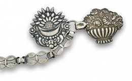 25.  Broche de capa en plata s.XVIII con dos centros florales y cadena y remate de bellota.