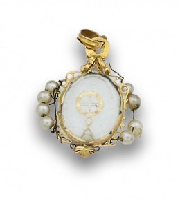 546.  Colgante s.XVIII con miniatura de ostensorio entre cristales con marco de filigrana de oro y símil perlas.