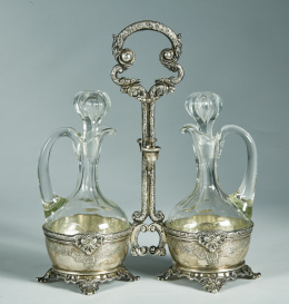 460.  Convoy de plata punzonada con decoración de estilo regencia francés, con aceitera y vinagrera de cristal tallado.principios del S. XX..