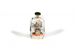 1315.  “Snuff-bottle” pintado bajo cristal a la manera de Liu Shouben.Decorada con un insecto en un paisaje fluvial y en el reverso una maceta con un almendro.China, S. XX.