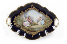 1094.  Bandeja de porcelana en el estilo de Sévres, esmaltada en azul real, con una escena galante y dorada en relieve.Francia,, Samson, S. XIX.