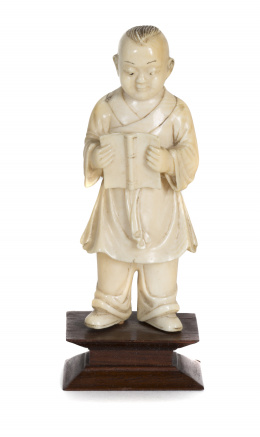 615.  “Niño chino leyendo”, escultura en marfil tallado y entintado.China, época de la república, S. XX