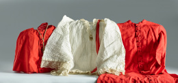 974.  Traje de monaguillo formado por roquete en algodón plisado con aplicaciones de encaje, una casulla en lana con botonadura y una capa.Trabajo español, S. XIX.