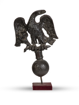 458.  Águila en hierro sosteniendo cuerno de la abundancia y láureas de la victoria sobre base de cañón.Atribuido a la Real Fábrica de Artillería de Sevilla, S. XVIII.