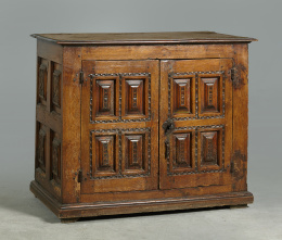 362.  Armario bajo de madera de nogal con decoración tallada en las puertas.Trabajo español, S. XVII..