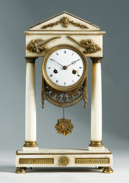 1099.  Reloj de pórtico en mármol y metal dorado y aplicado de estilo imperio.Francia, S. XIX-