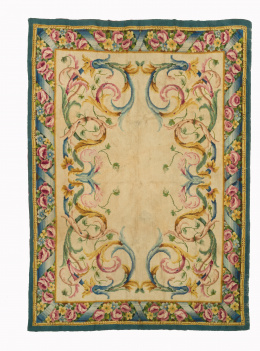 1053.  Alfombra en lana de Nudo español en beige, decorado con roleos, hojas, flores y cintas.Real Fábrica de tapices Madrid 1946. Fechada y firmado..