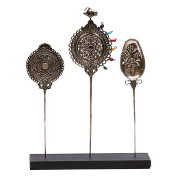 1075.  Conjunto de tres tupus de plata repujada con decoración repujada, aplicaciones de cristal y uno con una piedra engastada.Venezula o Perú, S. XVIII.