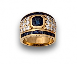659.  Sortija ancha con zafiro oval de 1,70 ctes aprox  entre pavé de brillantes y líneas de zafiros calibrados.