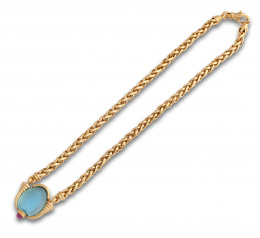 720.  Gargantilla con topacio azul tallado con gallones enmarcado entre columnas,coronado por cabuchón de rubí.