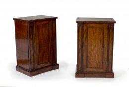 1087.  Pareja de mesitas victorianas en madera de caoba con tapa de cuero gofrado y puerta frontal entre arcos apuntados.Inglaterra, segunda mitad del siglo XIX.