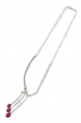 294.  Gargantilla con tres rubíes talla perilla como remate de cascada, en gargantilla de brillantes y baguettes con diseño asimétrico