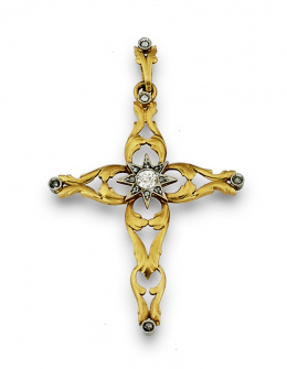 700.  Cruz colgante con estrella central de diamantes y brazos calados que dibujan formas vegetales rematados en chatones de brillantes.