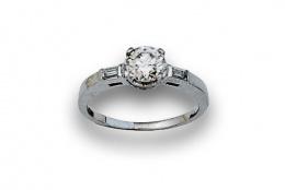 732.  Sortija con solitario de btes de 0,80 ctes aprox entre baguettes en montura de platino.