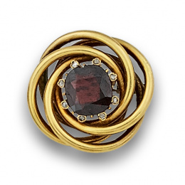 17.  Broche de pps s XX con granate rodeado de brillantes de talla antigua en chatón,en el centro de nido de hilos de oro.
