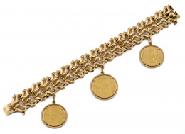 138.  Brazalete ancho articulado con piezas a modo de croissant en oro de 18K con tres monedas colgantes montadas en marcos sin soldar .
