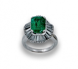 727.  Sortija con esmeralda de 3,90 ctes aprox en orla bailarina de diamantes trapecio en oro blanco de 18K.