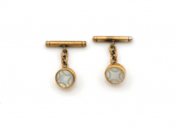 724.  Gemelos de pp s. XX con círculo de nácar y sistema de cadena y cilindro. En metal dorado.