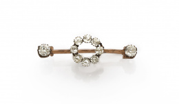 617.  Broche de fantasía años 30 con strass en círculo central y solitarios en los extremos.