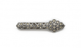 628.  Broche barra de fantasía, años 30, con strass en celdas de colmena que componen una banda con copete.
