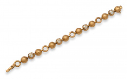 630.  Brazalete años 50 con perlas,semiesferas gallonadas y aros articulados; en oro de 18K.