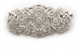 660.  Broche placa estilo años 40 de diamantes y con brillante central en montura geométrica con decoración calada en plata.