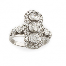 188.  Sortija lanzadera Art-Decó con tres brillantes alineados rodeados por orla de brillantes y chatones en los brazos de la montura. 