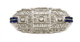 680.  Broche placa Art-Decó de diseño geométrico con brillantes diamantes y zafiros calibrados sintéticos en dos bandas laterales. 