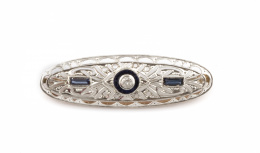 689.  Broche placa estilo Art-Decó ovalada con zafiros calibrados y diamantes con brillante en chatón central en montura de platino.