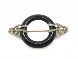 814.  Broche circular Art-Decó con aro de ónix abrazado por motivos de cintas de entrelazadas y marco lobulado de brillantes y diamantes