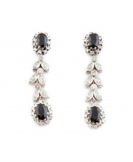 238.  Pendientes largos con zafiros ovales orlados de brillantes en cabeza y colgante, y entre ambos hojitas y chatones de brillantes articulados.