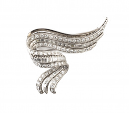 560.  Broche años 40 de platino y brillantes en forma de lazo asimétrico ondulado, con línea centra central de baguettes entre dos líneas de brillantes