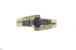 691.  Sortija con zafiro de talla oval entre zafiros calibrados y brillantes en los brazos asimétricos de la montura