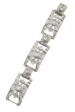 562.  Brazalete Art-Deco de platino y brillantes con diseño geométrico calado, compuesto por tres piezas rectangulares arquedas principales, articuladas por tres menores