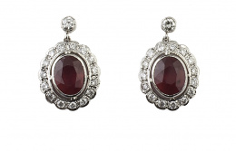 461.  Pendientes con rubíes de talla oval que suman 5,40 ct orlados de brillantes en marco lobulado, que penden de brillante en chatón superior