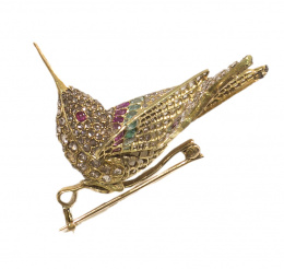 596.  Broche de pp. S. XX en forma de colibrí de bulto redondo, cuajado de diamantes ,con ojos de rubí y ermaraldas calibradas y rubíes adornando las alas.