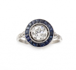 664.  Sortija ojo de perdiz con un brillante central de 1,05 ct aprox orlado de zafiros calibrados
