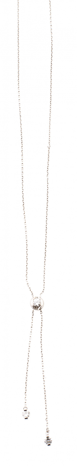 701.  Pendentif con brillante central orlado del que penden dos brillantes engastados al aire en dos garras. 