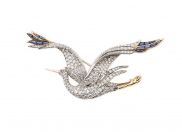757.  Broche con diseño de garza real, cuajado de brillantes y con zafiros calibrados como remate en las alas