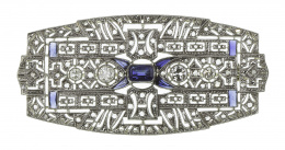 606.  Broche placa Art-Decó con diseño geométrico calado, cuajado de diamantes, y con cuatro chatones de brillantes en línea central 