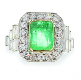 662.  Sortija con esmeraldacentral de 2,70 ct orlada de brillantes, y con diamantes baguette escalonados en los brazos de la montura