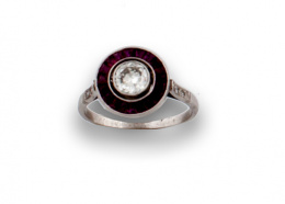 632.  Sortija ojo de perdiz con brillante de 0,60 ctes orlado de rubíes calibrados en montura de platino.