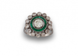 757.  Sortija Art Decó con ojo de perdiz central ,de brillante de 0,60 ctes, orlado de esmeraldas calibradas. Con orla exterior de chatones de brillantes