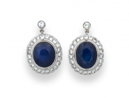 31.  Pendientes con zafiro oval orlado de brillantes que penden de chatón de brillante.