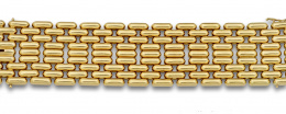 631.  Brazalete ancho de GREGORY  con nueve bandas de piezas articuladas en  oro de 18K. Transformable en collar