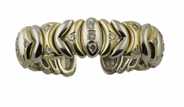 386.  Brazalete flexible gallonado en oro bicolor de 18K, con brillantes que suman 2,40 ct.