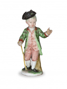 1303.  Niño con traje de rayas y casaca verde de porcelana esmaltadaS. XVIII.