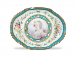 1290.  Fuente de porcelana esmaltada. con decoración "enjoyada "y flores, tondo con retrato femenino. Marca en azul cobaltoSévres, ffs. del S. XVIII.
