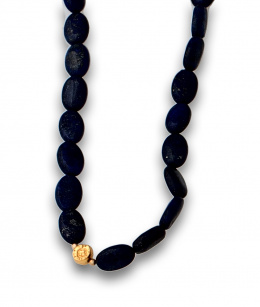 630.  Collar largo de cuentas ovaladas de lapislázuli con entrepiezas de plata dorada.
